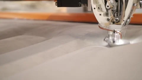 Worker sewing edges of mattress with help equipment in factory indoors. Stock Footage 240757601
