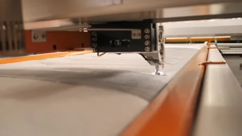Worker sewing edges of mattress with help equipment in factory indoors. Stock Footage 240757610