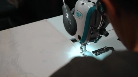 Worker sewing tag onto material Stock Footage 135160888