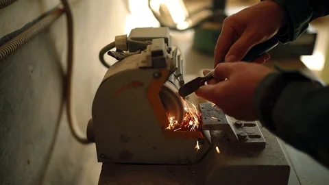Worker sharpening a chisel on a sharpening machine. Woodworker sharpening chisel Stock Footage 124692090