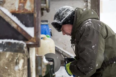Worker sharpens a chisel on the emery wheel 스톡 사진