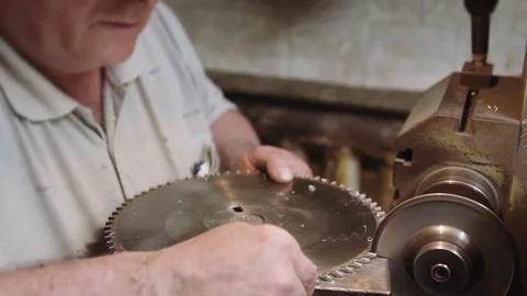 Worker sharpens a circular saw blade – medium shot Stock Footage 75708688