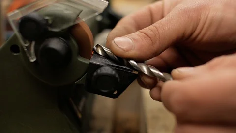 Worker sharpens drill on grinding machine close up. 4k Stock Footage 105638013