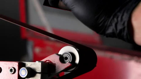A worker sharpens a steel knife on a machine, sparks fly from the sharp blade Stock Footage 279402220