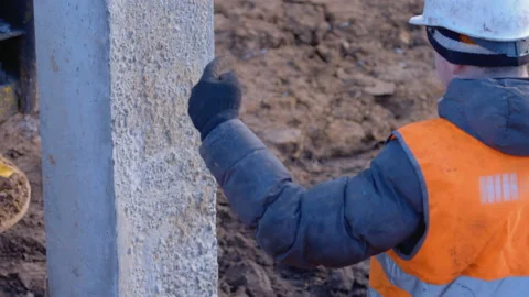Worker shows point in the ground where the concrete pile should be driven  Stock Footage 161953304