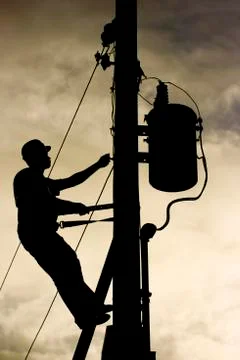 Worker silhouette at a power line post Stock Photos