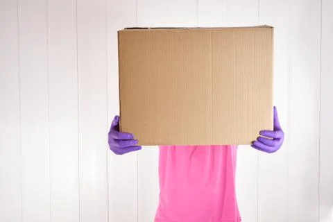 Worker with single-use gloves picking up cardboard box Stock Photos