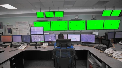 A worker sits in front of many monitors. Green screen with markers. Productio Stock Footage 127099286