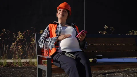 Worker Sitting and Relaxing on a Bench while using a Smartphone Stock Footage 311858701