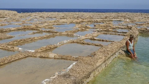 Worker sitting inside salt pans in Malta Mediterranean sea Video stock 108390389