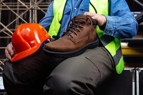 Worker sitting with leather boot. Stock Photos
