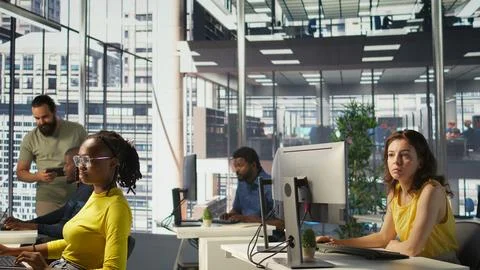 Worker sitting at office desk using computer during job shift Foto stock