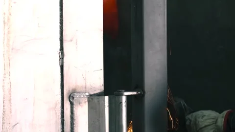 Worker skillfully grinds metal part with pneumatic tool in workshop 動画素材 311429276