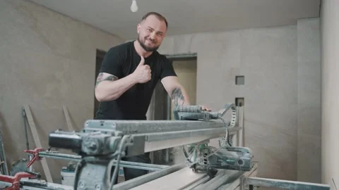 Worker skillfully uses tool to cut tiles in a modern workshop Video stock 317378091