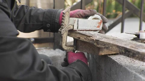 A worker skillfully using a clamp tool on a wooden plank as part of the Stock Footage 314710968
