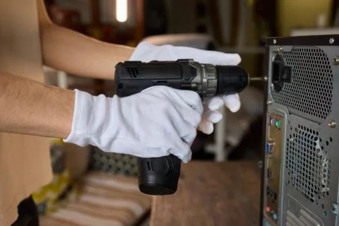 A Worker Skillfully Using a Power Drill for the Purpose of Computer Repair and Foto stock