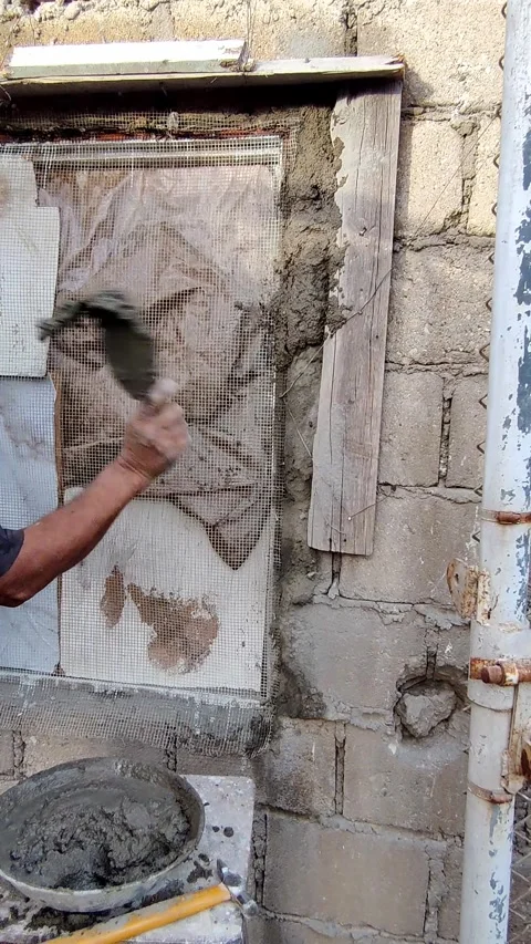 Worker slapping fresh plaster on old window frame for strong grip Stock Footage 333196981
