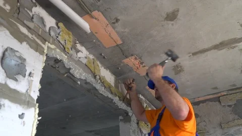 Worker with a sledgehammer breaks a wall, the wall collapses Stock Footage 115438429