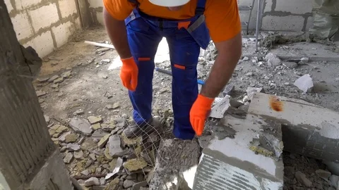 Worker with a sledgehammer breaks a wall, the wall collapses Stock Footage 115438728