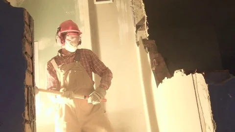 Worker with sledgehammer at indoor wall destroying 動画素材 84179466