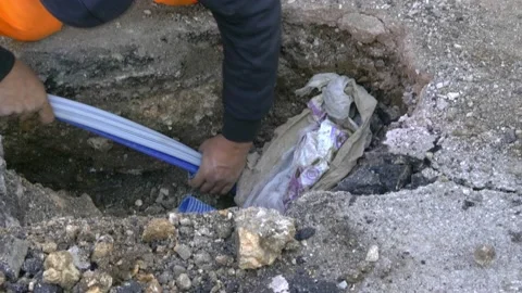 Worker slips fiber optic cables into underground corrugated pipe Video stock 147860332