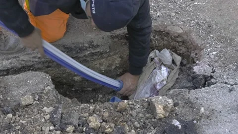 Worker slips fiber optic cables into underground corrugated pipe Video stock 147860336