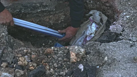 Worker slips fiber optic cables into underground corrugated pipe Video stock 211373332
