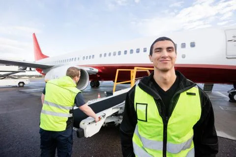 Worker Smiling While Colleague Working On Runway Foto stock