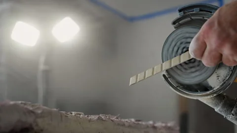 Worker smoothing ceramic tile angle with tile cutter on workbench during a home Stock-Footage 320144384