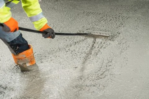 Worker Smoothing Fresh Concrete Surface with Tool for Leveling and Finishing Stock Photos
