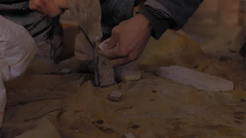 Worker smoothing an object with a hammer on a building site to build house Видео 110771487