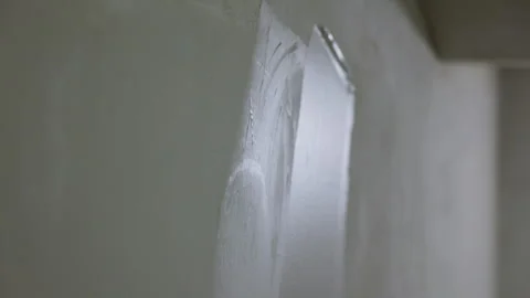 Worker smoothing plaster on interior wall with wide putty knife Vidéo 347160271
