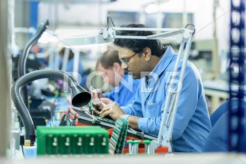 Worker Soldering Component Onto Circuit Boards In Circuit Board Assembly Factory