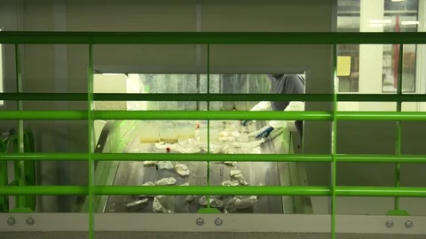 Worker sorting plastic bottles on a conveyor belt in a recycling plant Stock Footage 93530497