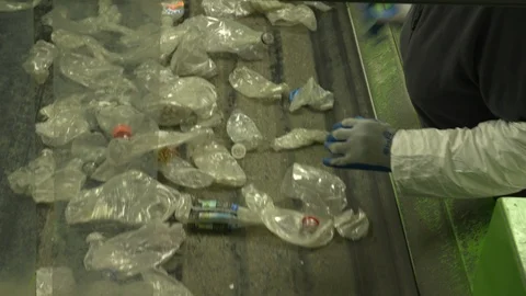 Worker sorting plastic bottles on a conveyor belt in a recycling plant 動画素材 93530580