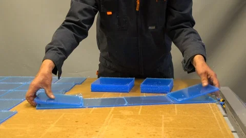 Worker sorting plastic parts, after cnc milling cutting. Man collects order Stock Footage 119398288