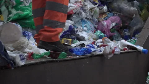 A worker sorting plastic waste inside a recycling center Stock Footage 263611940