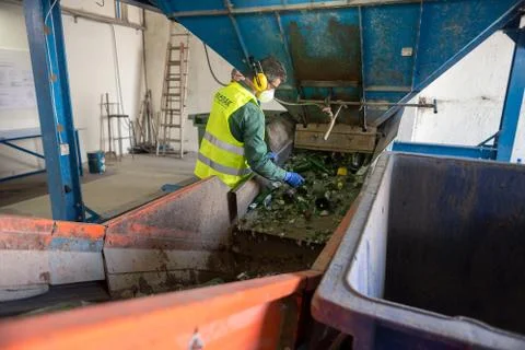 Worker is sorting the recyclable glass material and removing non recyclable t Stock Photos