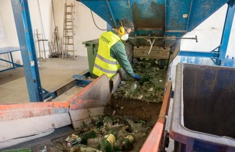 Worker is sorting the recyclable glass material and removing non recyclable t Stock Photos
