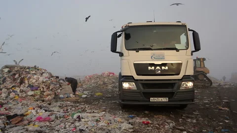 A worker sorts out garbage at a large landfill. Stock Footage 230883670