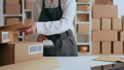 A worker in special clothes works in a parcel warehouse scans parcels for de Stock Footage 229735816