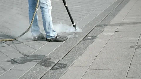Worker with special device and metal hose clear the street with hot steam. Stock Footage 49905142