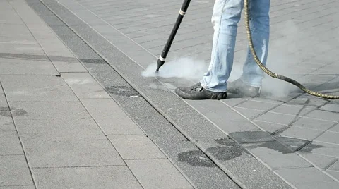 Worker with special device, long metal hose cleaning street flloor, hot steam. Video stock 46757941