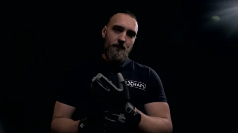 Worker specialist goes to the camera and puts on gloves on a black background Stock Footage 151646311
