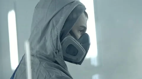 Worker spray paints a car in another color in a garage in slow motion Stock Footage 58923901