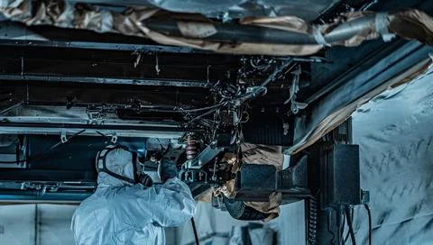 Worker Spraying Protective Undercoating Beneath a Car in Auto Workshop Stock Photos