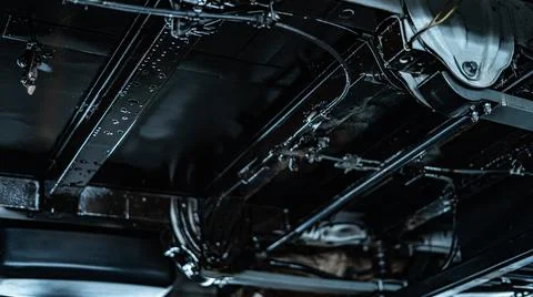 Worker Spraying Protective Undercoating Beneath a Car in Auto Workshop Stock Photos