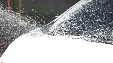 Worker spraying soap foam and washing a vehicle in professional car wash station Video stock 197555138