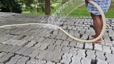 Worker Spraying Water On Interlocking Concrete Paver Blocks For Curing Close Up Stock Footage 342934121
