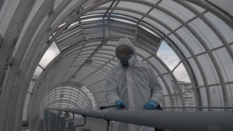 Worker sprays a disinfectant solution on the railing 스톡 동영상 129332390